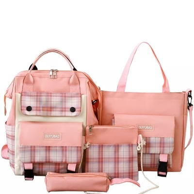 Las muchachas de la lona enseñan prenda impermeable de la universidad del sistema del bolso que la bolsa de libros linda fija la cartera