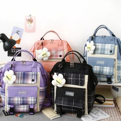 Las muchachas de la lona enseñan prenda impermeable de la universidad del sistema del bolso que la bolsa de libros linda fija la cartera