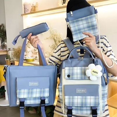 Las muchachas de la lona enseñan prenda impermeable de la universidad del sistema del bolso que la bolsa de libros linda fija la cartera